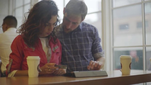 Couple making online purchase with digital tablet