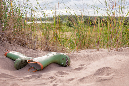 a pair of kid's rubber boots in sand