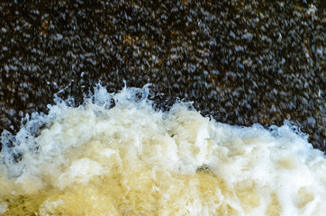 Obraz na płótnie Canvas River in motion nature background. Foaming water on the rapids of the river