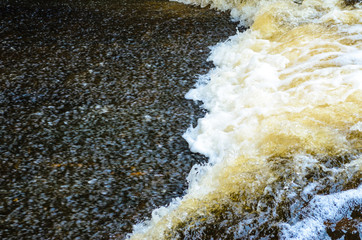 River in motion nature background. Foaming water on the rapids of the river