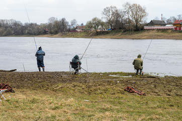 Three fishermen on the river bank