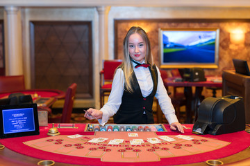 Cute lady casino dealer at Black Jack table.
