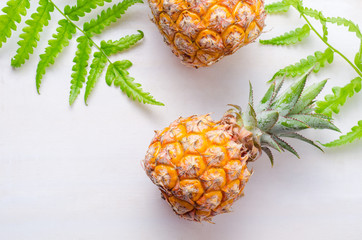 Ripe pineapples on white wooden table background
