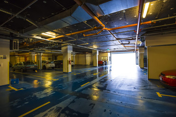 Empty places in colorful underground garage, wet floor and incoming sunlight