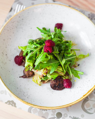 Close-up Warm salad, Duck liver with raspberry sauce, Arugula, raspberries, plate, tasty, fashionable food, restaurant, beautiful new dish serving, top view