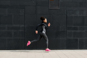 Side view of young female runner, outdoor training