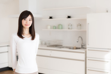 attractive asian woman relaxing in kitchen