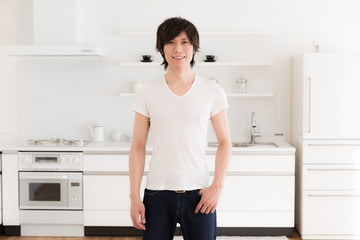 Fototapeta na wymiar young asian man relaxing in kitchen