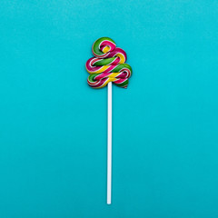 Lollipop Flat lay Minimal concept Colorful lollipop on a blue background One spiral candy on a stick
