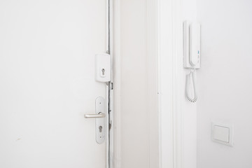 door handle , bar lock and interphone system on white apartment door