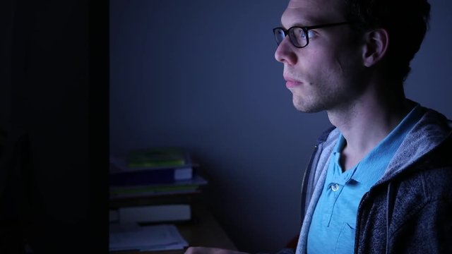 man working on computer by night at home, deadline for freelancer