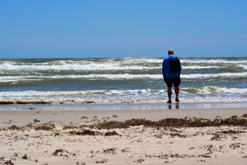 Wave Stare/Man standing in the tide, staring out at the ocean