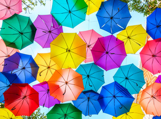 Multi-colored umbrellas background. Colorful umbrellas floating above the street. Street decoration. © somchairakin