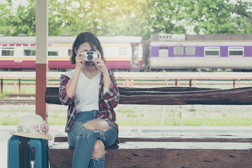 Enjoying travel. Young pretty woman traveling and classic train with sunny at railway platform. alone travel and summer concept. vintage filter.