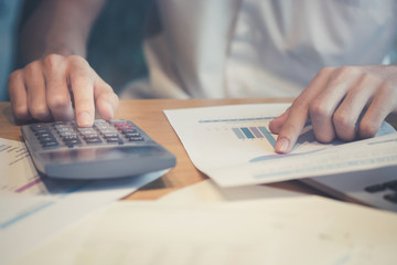 Close up Business man using calculator and laptop computer for calculating with finance paper, tax, accounting, Accountant concept.