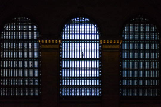 Fototapeta Man passing on the walkway above the main concourse of the station. Beautiful windows can be seen