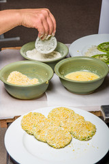 Applying cornmeal dredge to tomato slices