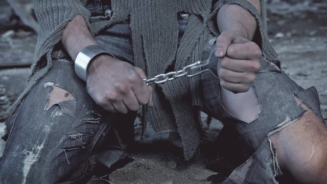 a prisoner in chains on his knees