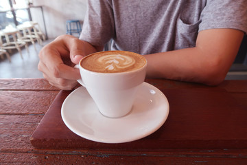 Man drinking hot coffee in coffee shop.