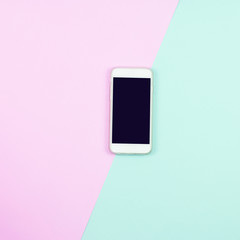 Blank smart phone on pink and blue background. top view.