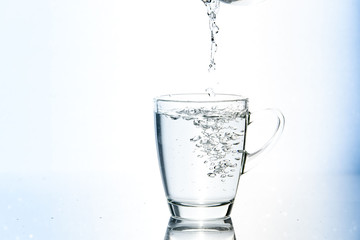 Naklejka na ściany i meble Pouring water in glass