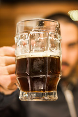 Close up of a man dolding a dark beer, delicious craft beer Booze Brew Alcohol Celebrate
