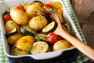Spicy potatoes baked with zucchini, bell pepper and tomatoes close-up. horizontal