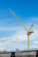 Yellow construction crane with blue sky in Bangkok, Thailand