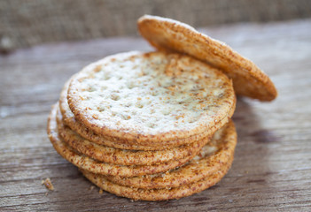 Round crackers on wooden texture and background, baked goods 