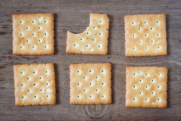 Crackers or biscuit on wooden background, top view