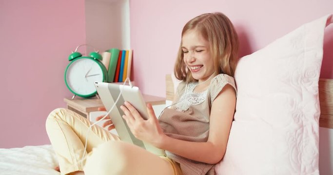 Girl using tablet and laughing at camera
