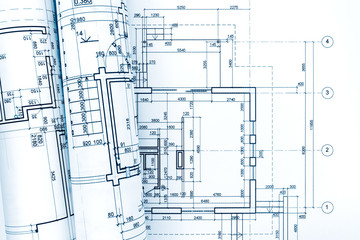 architectural plan with rolled blueprints of house renovation