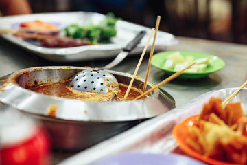 Warming satay sauce in the pot. Satay is a dish of skewered grilled meat with Javanese origins in Malacca City, Malacca, Malaysia.