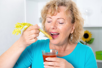 young woman and her mother drinking tomato juice together in the