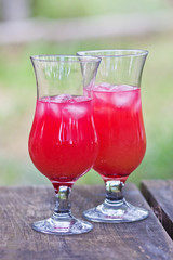 Two cocktail glasses with a bright red cocktail. Ice in a glass. Refreshing drink. Thirst quenching
