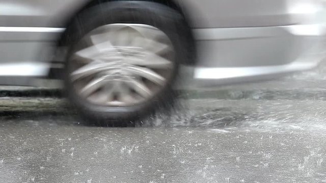 Rain on the road and the car runs through