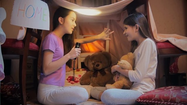 4k Video Of Two Sisters In Pajamas Telling Stories With Flashlight At Night