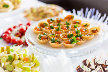 A small table with a delicious buffet of canapes, caviar, sandwiches