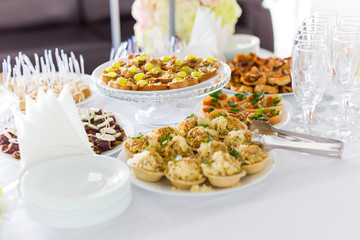 A small table with a delicious buffet of canapes, caviar, sandwiches