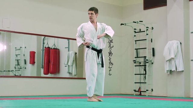 The sportsman in white clothes performing a karate 4k