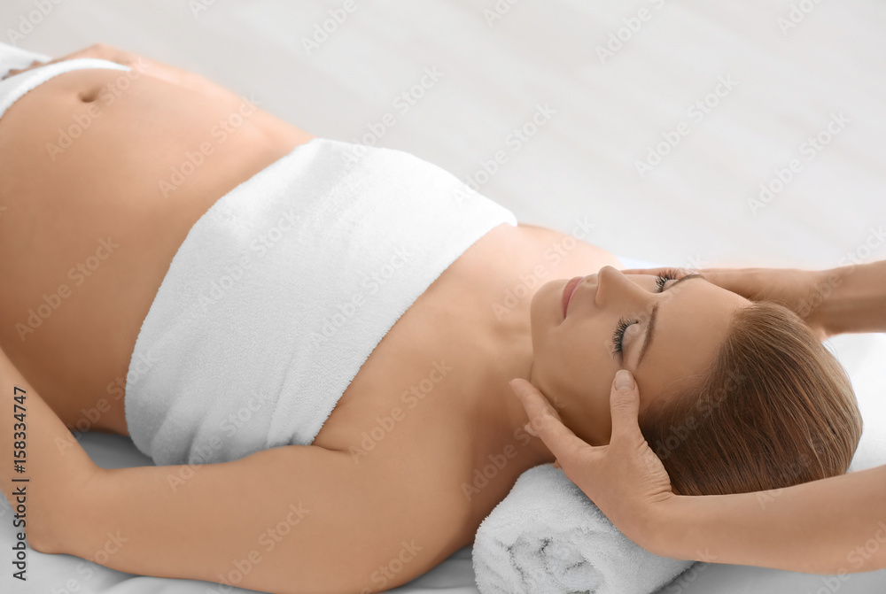 Poster Young beautiful pregnant woman having massage in spa salon