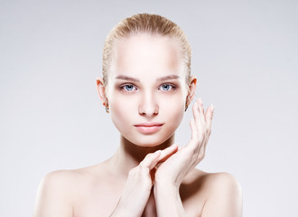 Beautiful Young Woman with Clean Fresh Skin touch own face . Facial treatment . Cosmetology , beauty and spa .