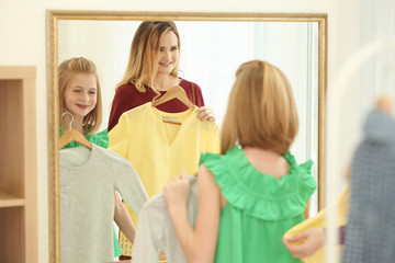 Mother and daughter choosing clothes in modern shop