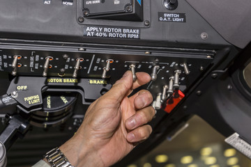 Switching tumblers by pilot in the cockpit of the helicopter. Focus on hand.