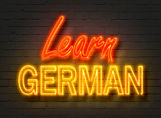 Learn German, neon sign on brick wall