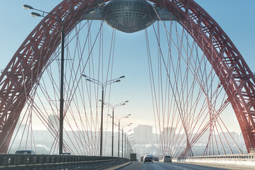 Obraz premium winter road goes under the red bridge. frosty winter highway.