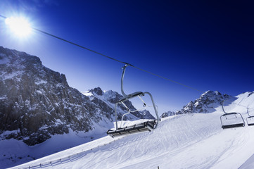 Fototapeta na wymiar Winter mountains, panorama - snow-capped peaks. Ski lift.
