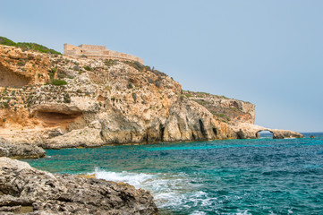 Rocky coastline with Saint Mary's Battery in Comino Island in Malta.