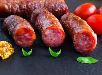 Grilled sausage on a stone dark board