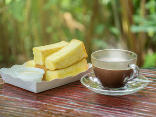 Hot cocoa in cup with bread baked with butter and condensed milk
